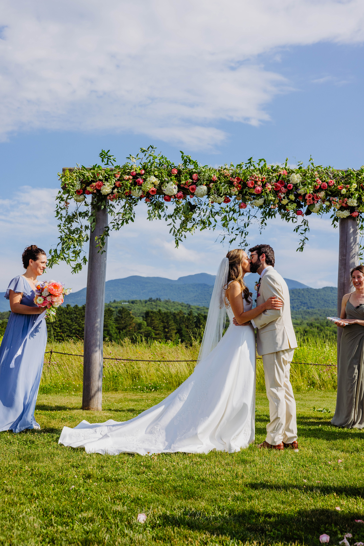 Stowe VT mountain view romantic wedding florals wedding pink and citrus wedding ceremony arch flowers and bride and groom after the ceremony by a Burlington Vermont Wedding Florist at the Barn at Smugglers Notch wedding venue