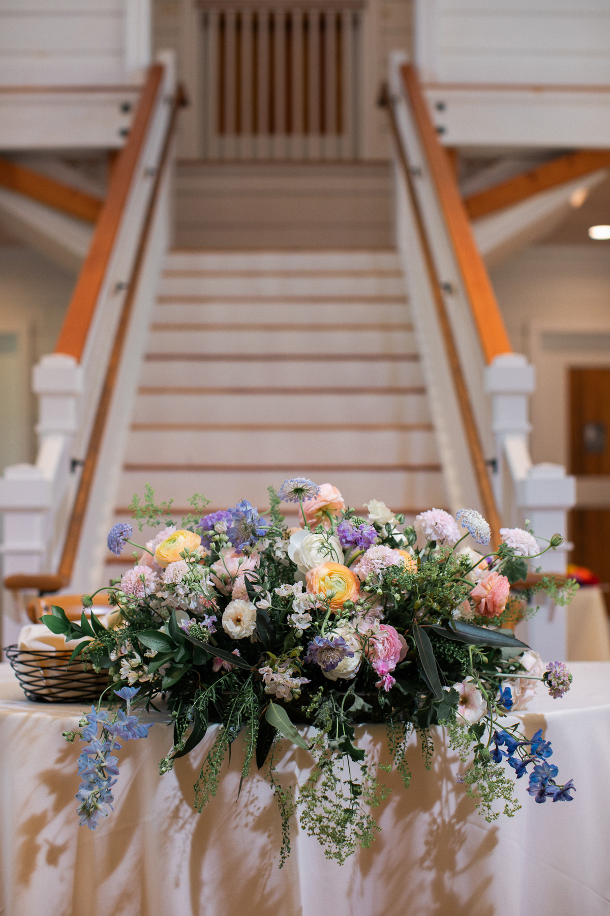 Mountain view summer wedding pastel bridal bouquet summer wedding flowers and invitations by a vermont wedding florist at the Barn at Smugglers' Notch wedding venue bride and groom at their reception sweetheart table floral design