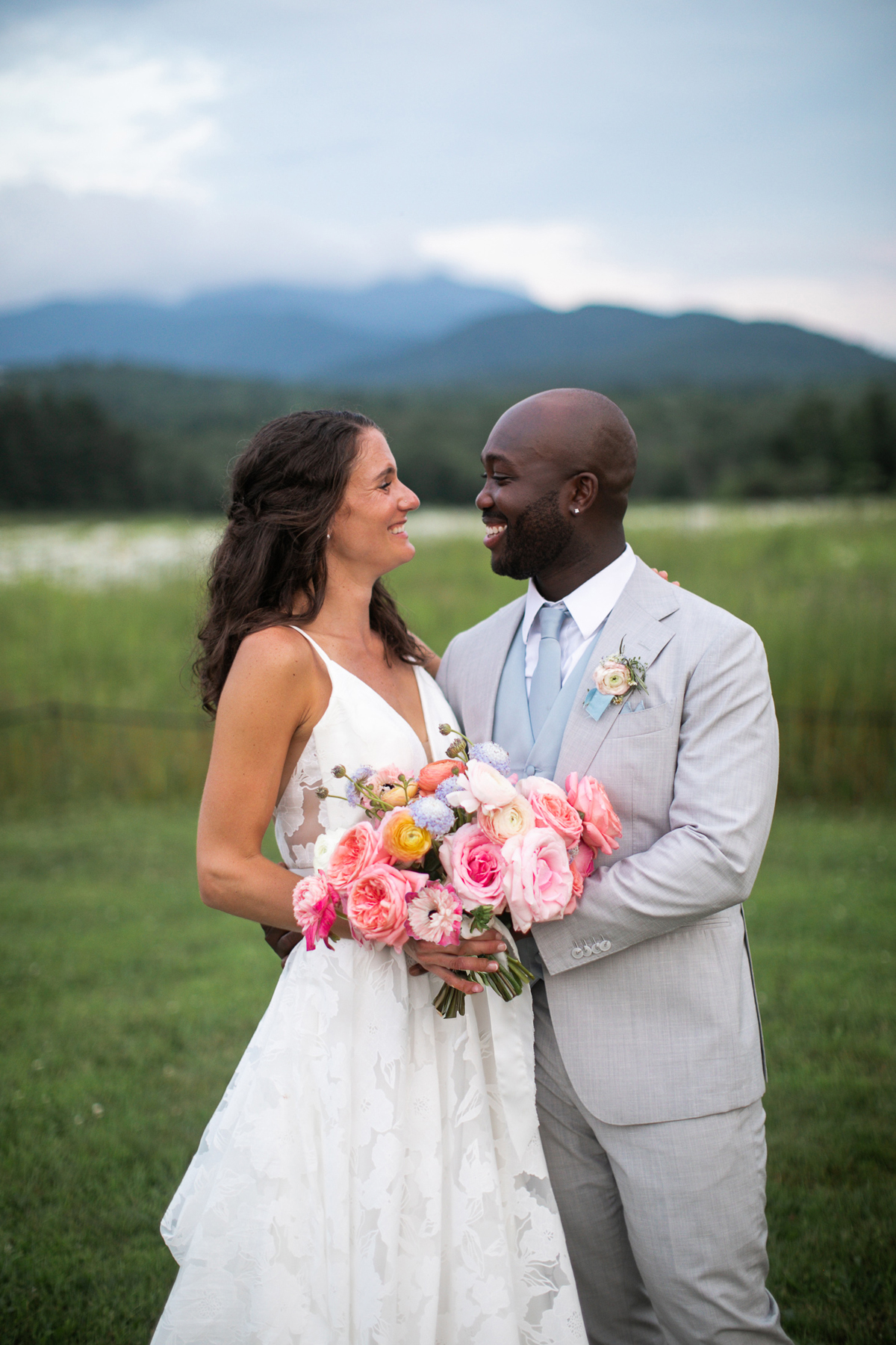 Mountain view summer wedding pastel bridal bouquet summer wedding flowers and invitations by a vermont wedding florist at the Barn at Smugglers' Notch wedding venue bride and groom