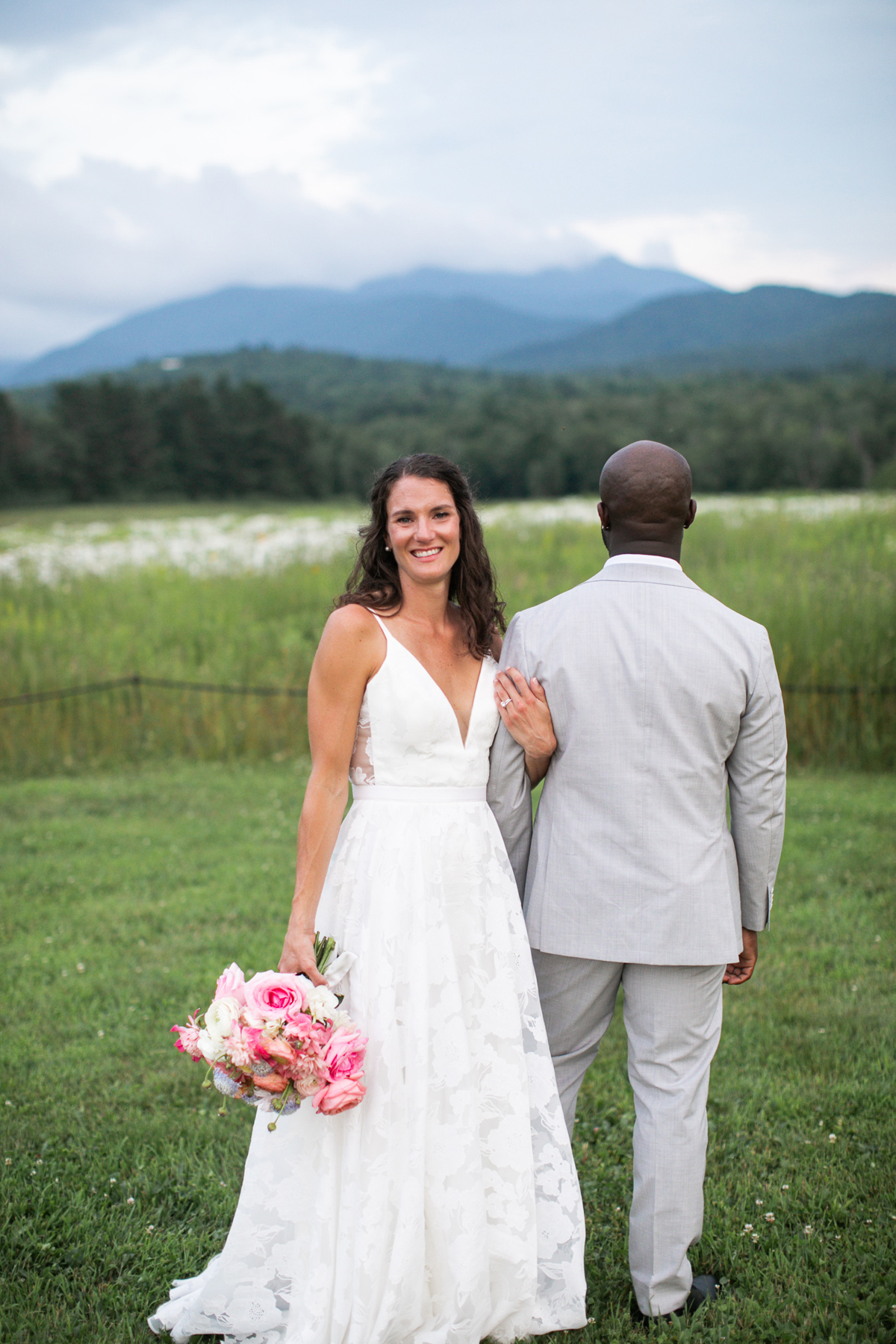 Mountain view summer wedding pastel bridal bouquet summer wedding flowers and invitations by a vermont wedding florist at the Barn at Smugglers' Notch wedding venue bride and groom