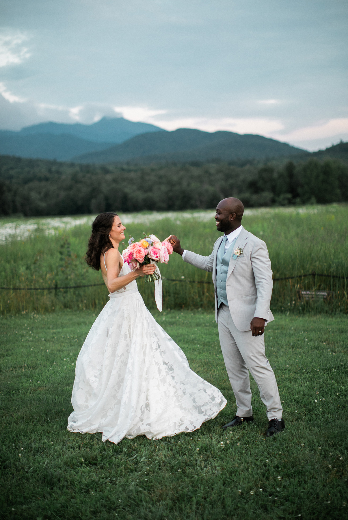 Mountain view summer wedding pastel bridal bouquet summer wedding flowers and invitations by a vermont wedding florist at the Barn at Smugglers' Notch wedding venue bride and groom